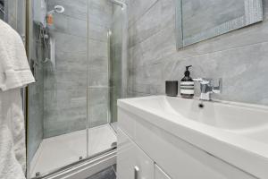 y baño con lavabo blanco y ducha. en Pelican Suite - Design 1Bed Flat en Harrogate