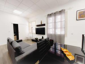 sala de estar con sofá y TV de pantalla plana en Alojamiento San Juan en Murcia Centro, en Murcia