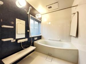 ein Badezimmer mit einer Badewanne und einem Waschbecken in der Unterkunft 神津島民宿菊乃屋～きくのや～kikunoya in Kōzushima