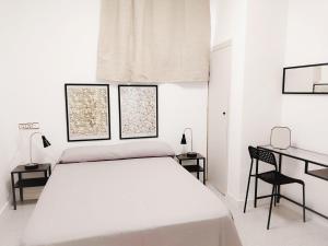 a white bedroom with a bed and a desk at Alojamiento San Juan en Murcia Centro in Murcia