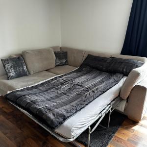 a couch with a blanket on top of it at Two Bedroom Flat Town Centre Colchester in Colchester