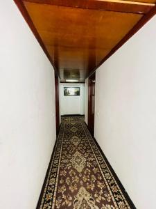 an empty hallway with a rug on the floor at HOTEL PLAZA GRAND in Jalandhar