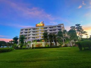 a large building with a green field in front of it at Phuphanplace Hotel in Ban Phang Khwang Tai