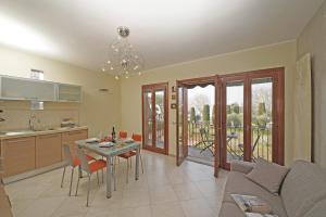 a kitchen and living room with a couch and a table at Apt Il Barcone - Gardagate in Sirmione +30 photos