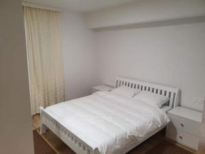 - une chambre avec un lit blanc et une fenêtre dans l'établissement NG Natural Garden, à Sarajevo