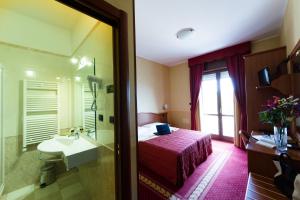um quarto de hotel com uma cama, um lavatório e um espelho em Vald Hotel em Val Della Torre