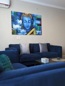 uma sala de estar com sofás azuis e uma pintura na parede em Buddha Vista Luxury apartment em Ulaanbaatar