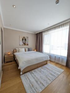 een slaapkamer met een groot bed en een groot raam bij Buddha Vista Luxury apartment in Ulaanbaatar