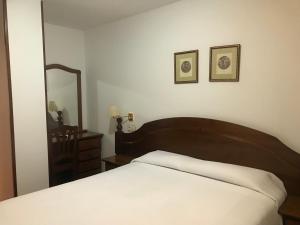 a bedroom with a bed and a large mirror at Hostal O Portiño in Rianjo