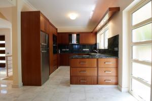 eine Küche mit Holzschränken und einem Waschbecken in der Unterkunft Amorosa Beach Villa 6 in Neo Chorio
