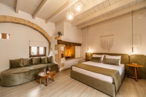 a large bedroom with a bed and a couch at Lithinon Luxury Suites in Chania