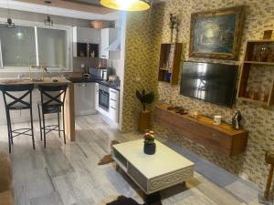 a living room with a kitchen with a table and a counter at Superbe appartement sahloul 4 in Sousse