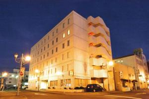 un gran edificio blanco en una calle de la ciudad por la noche en Smile Hotel Kushiro, en Kushiro