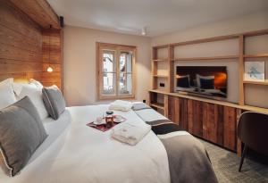 uma grande cama branca com uma bandeja de comida em Alliey & Spa Piscine Appart-hôtel Serre chevalier em Le Monêtier-les-Bains