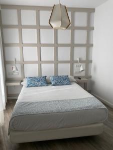 a bedroom with a large bed with blue pillows at Hotel Boutique Teatro Romano in Málaga