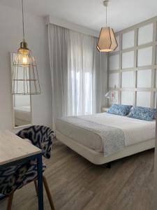 sypialnia z łóżkiem, krzesłem i oknem w obiekcie Hotel Boutique Teatro Romano w Maladze