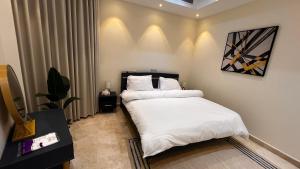 1 dormitorio con 1 cama con sábanas blancas en شقة غرفتين وصاله مطله على البحر برج ابحر ريزيدنس 1 en Obhor