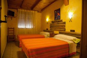 2 camas en una habitación con paredes amarillas en La Derrubiá en Villamalea