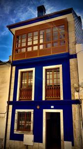 ein blaues Gebäude mit Fenstern auf einer Straße in der Unterkunft MartinVidal 2 in Luarca