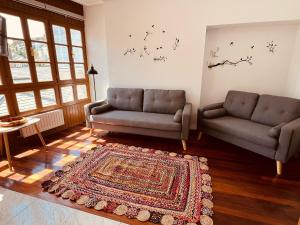 ein Wohnzimmer mit 2 Sofas und einem Teppich in der Unterkunft MartinVidal 2 in Luarca