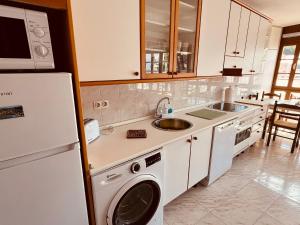a kitchen with a washer and a sink and a refrigerator at MartinVidal 2 in Luarca +4 photos