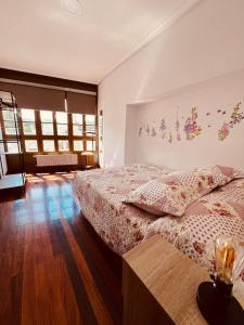 ein Schlafzimmer mit einem Bett in einem Zimmer mit Holzböden in der Unterkunft MartinVidal 2 in Luarca
