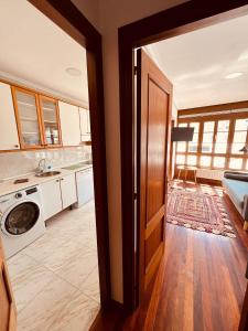 eine offene Tür zu einer Küche mit Waschmaschine und Trockner in der Unterkunft MartinVidal 2 in Luarca