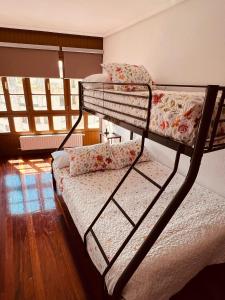 ein Schlafzimmer mit einem Etagenbett mit Blumen darauf in der Unterkunft MartinVidal 2 in Luarca