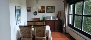 a dining room with a table and some windows at Haus am Wald in Lissendorf