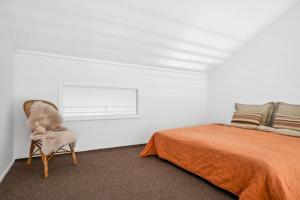 ein Schlafzimmer mit einem Bett und einem Stuhl neben einem Bett in der Unterkunft Come Stay 3BR - Havudsigt m.plads til 5 personer in Hørsholm