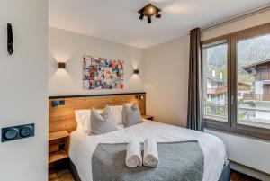 Un dormitorio con una cama con dos pares de zapatos. en White Pearl A15 - Alpes Travel - Central Chamonix – Sleeps 4, en Chamonix-Mont-Blanc