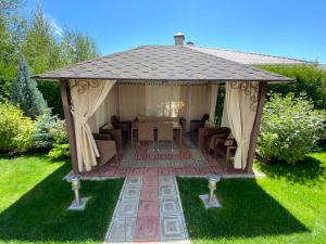 a gazebo with a table and chairs in a yard at Karven Four Seasons in Chok-Tal