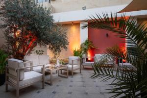 eine Terrasse mit Stühlen, einem Tisch und Pflanzen in der Unterkunft Corp Amman Hotel in Amman