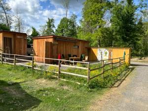 uma cabana de madeira com uma cerca ao lado de uma estrada em Bosruck Chalet em Misselsdorf