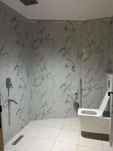 baño con pared de mármol y aseo en جولدن سيف Golden Sword en Mogayra