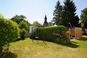 a yard with a swing set in the grass at Ferienhaus Geli 4 in Kröslin