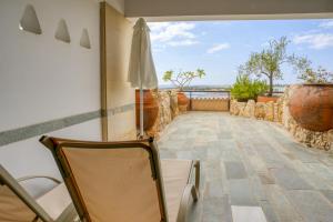 een kamer met een balkon met een stoel en een paraplu bij Coral Beach Hotel & Resort Cyprus in Coral Bay