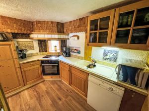 una cocina con armarios de madera y fregadero en Apartment Helmreich-2 by Interhome, en Sankt Gallenkirch