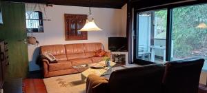a living room with a leather couch and a table at Haus am Wald in Lissendorf