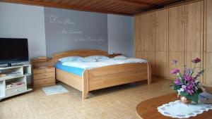 a bedroom with a bed and a tv and a table at Ferienwohnung Stocker in Traitsching