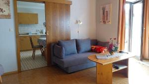 a living room with a blue couch and a table at Ferienwohnung Stocker in Traitsching