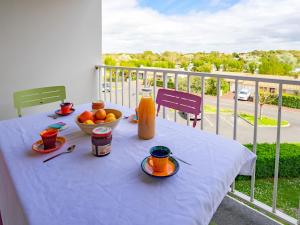 uma mesa com uma tigela de fruta numa varanda em Apartment Les Jardins de l'Océan-10 by Interhome em Pontaillac