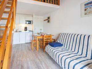 uma sala de estar com um sofá e uma cozinha em Apartment Les Jardins de l'Océan-10 by Interhome em Pontaillac