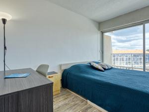 ein Schlafzimmer mit Bett, Schreibtisch und Fenster in der Unterkunft Apartment Casino-5 by Interhome in Lacanau-Océan