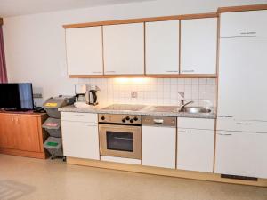 eine Küche mit weißen Schränken und einem Waschbecken in der Unterkunft Holiday Home Subretta - KPL094 by Interhome in Kappl