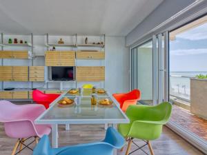 ein Esszimmer mit einem Tisch und bunten Stühlen in der Unterkunft Apartment Casino-5 by Interhome in Lacanau-Océan