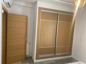 a closet with wooden doors in a room at Superbe appartement sahloul 4 in Sousse