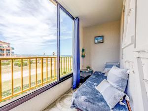 a bedroom with a balcony with a view of the ocean at Apartment Palm Beach-5 by Interhome in Le Barcarès