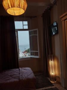 a room with a bed and a window and a light at Alexander spot in Alexandria