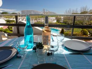 una mesa con una botella de vino y copas en Apartment Du Soleil-3 by Interhome, en La Grande-Motte